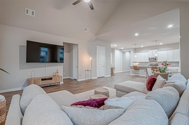 living area featuring ceiling fan, visible vents, baseboards, recessed lighting, and light wood-style flooring