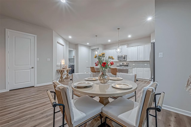 dining space with baseboards, recessed lighting, and wood finished floors