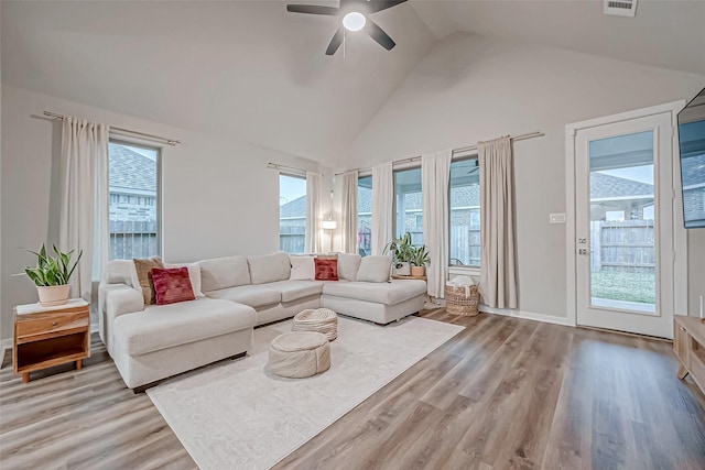 living room featuring ceiling fan, a wealth of natural light, light wood-style flooring, and high vaulted ceiling