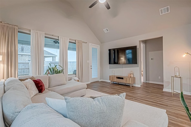 living room featuring baseboards, ceiling fan, visible vents, and wood finished floors