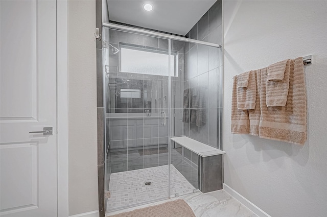 full bath with baseboards, marble finish floor, and a shower stall