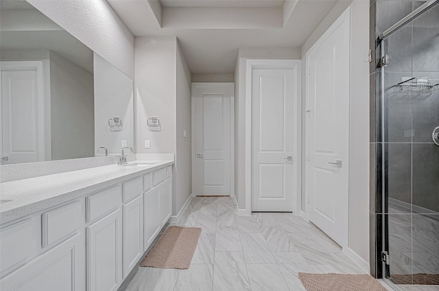 full bath with vanity, marble finish floor, baseboards, and a stall shower
