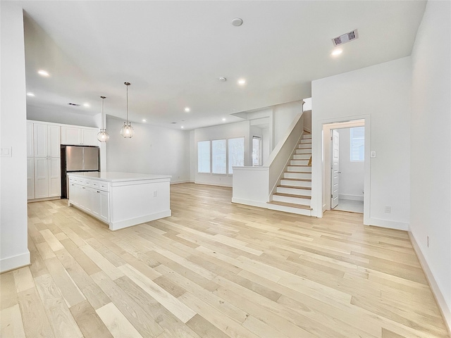 7705 Westside Villas Ln, Houston, TX 77055 - kitchen featuring freestanding refrigerator, white cabinetry, visible vents, light wood-type flooring, and recessed lighting