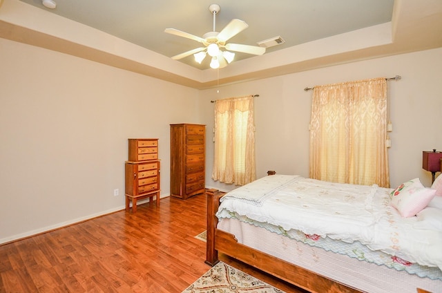 24242 Yelverton Glen Dr, Katy, TX 77493 - bedroom featuring ceiling fan, visible vents, wood finished floors, baseboards, and a tray ceiling