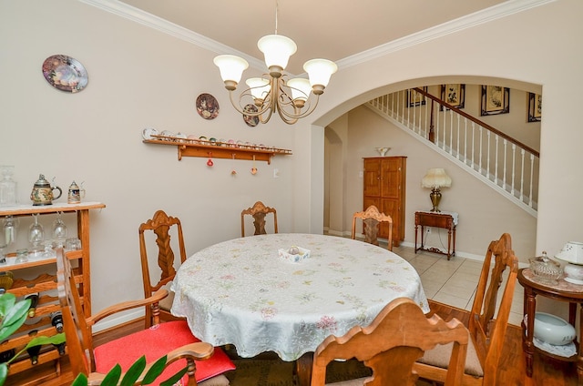 24242 Yelverton Glen Dr, Katy, TX 77493 - dining space featuring arched walkways, wood finished floors, an inviting chandelier, ornamental molding, and stairs