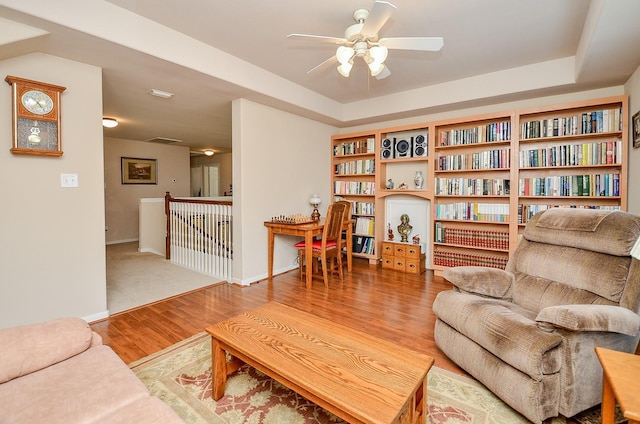 24242 Yelverton Glen Dr, Katy, TX 77493 - living area featuring ceiling fan, baseboards, a tray ceiling, and wood finished floors