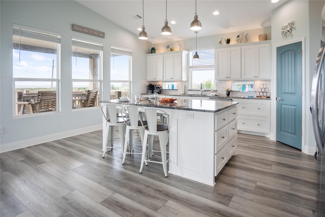 4413 Strand Ave, Port Bolivar, TX 77650 - kitchen with a center island, recessed lighting, backsplash, a sink, and white cabinetry