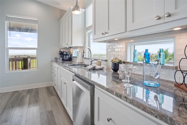 4413 Strand Ave, Port Bolivar, TX 77650 - kitchen featuring dishwasher, a sink, stone countertops, white cabinetry, and backsplash