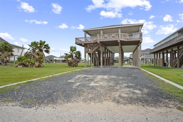 4413 Strand Ave, Port Bolivar, TX 77650 - view of front of house with a carport, a front yard, stairway, gravel driveway, and a residential view