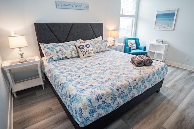 bedroom with baseboards and wood finished floors