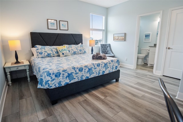 4413 Strand Ave, Port Bolivar, TX 77650 - bedroom with wood finished floors, baseboards, and ensuite bath