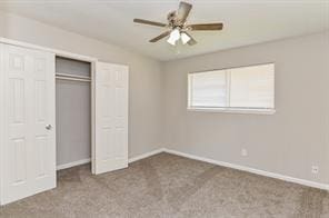 unfurnished bedroom featuring carpet floors, baseboards, ceiling fan, and a closet