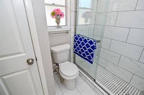 full bath with a tile shower and toilet