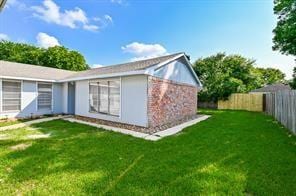 rear view of house featuring a yard and fence