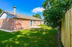 rear view of house featuring a lawn, fence, and a chimney