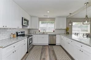 kitchen with white cabinetry, backsplash, dark wood-style floors, and stainless steel appliances