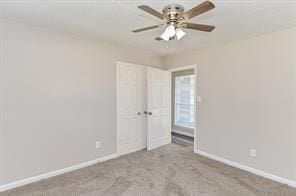 spare room with baseboards, carpet flooring, and ceiling fan