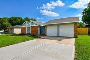 mid-century home with an attached garage, an outdoor structure, a front yard, and concrete driveway