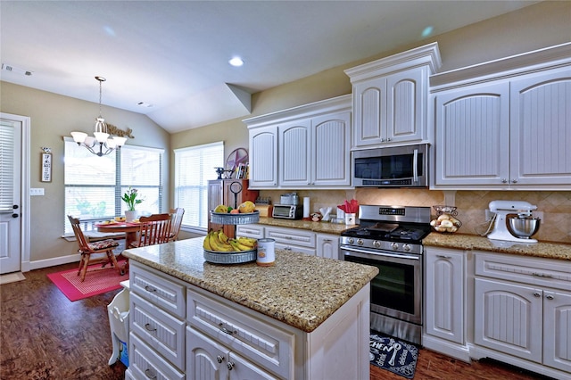 112 Timberside Dr, Conroe, TX 77304 - kitchen with appliances with stainless steel finishes, a chandelier, dark wood finished floors, decorative backsplash, and lofted ceiling