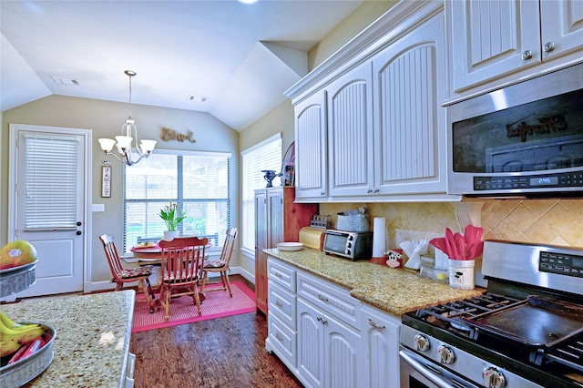 112 Timberside Dr, Conroe, TX 77304 - kitchen featuring stainless steel appliances, a chandelier, vaulted ceiling, dark wood finished floors, and baseboards
