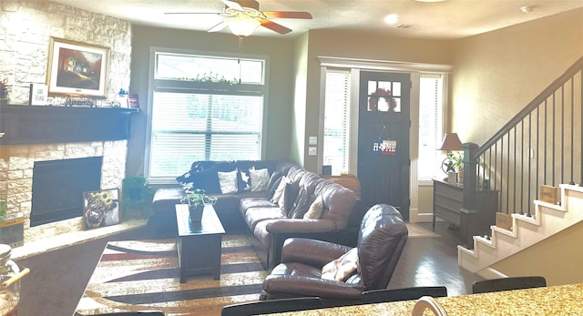 112 Timberside Dr, Conroe, TX 77304 - living area with wood finished floors, a ceiling fan, a stone fireplace, and stairway