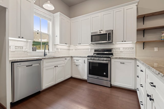 1708 Shearn St, Houston, TX 77007 - kitchen featuring appliances with stainless steel finishes, a sink, open shelves, white cabinets, and decorative backsplash