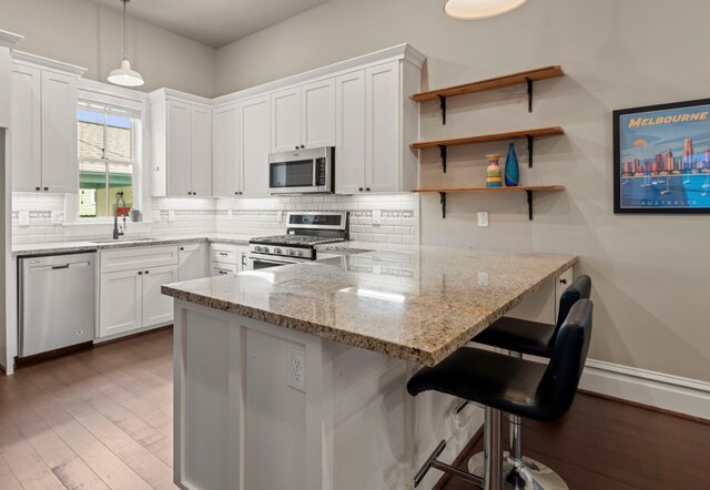 1708 Shearn St, Houston, TX 77007 - kitchen with stainless steel appliances, a sink, backsplash, and a peninsula