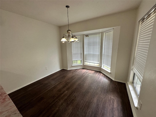 unfurnished dining area with baseboards, a notable chandelier, and dark wood-style floors