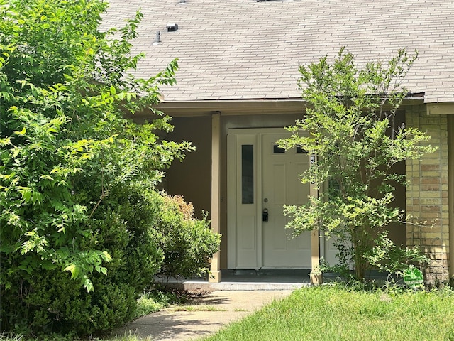 view of exterior entry featuring brick siding