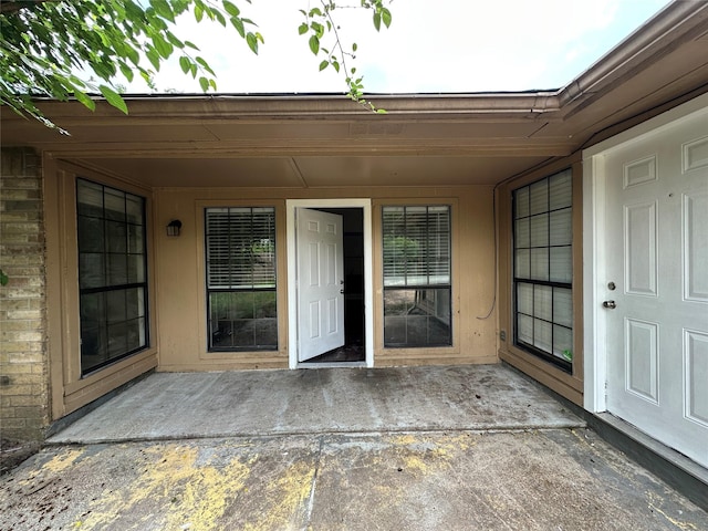 view of exterior entry with a patio