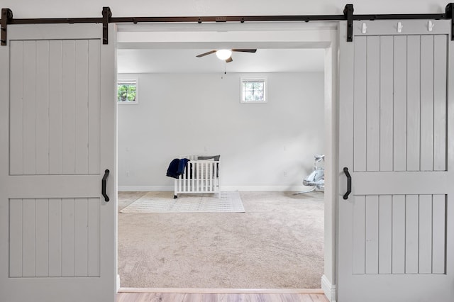 9948 Roda Dr, Conroe, TX 77303 - interior space with carpet floors, baseboards, a ceiling fan, and a barn door