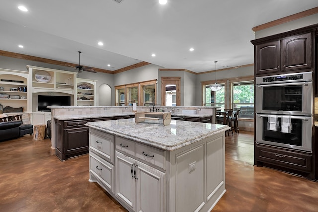9948 Roda Dr, Conroe, TX 77303 - kitchen featuring finished concrete flooring, ceiling fan, stainless steel double oven, and a center island