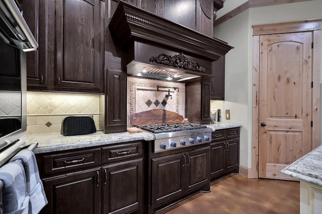 9948 Roda Dr, Conroe, TX 77303 - kitchen featuring concrete flooring, dark brown cabinetry, light stone countertops, stainless steel appliances, and tasteful backsplash