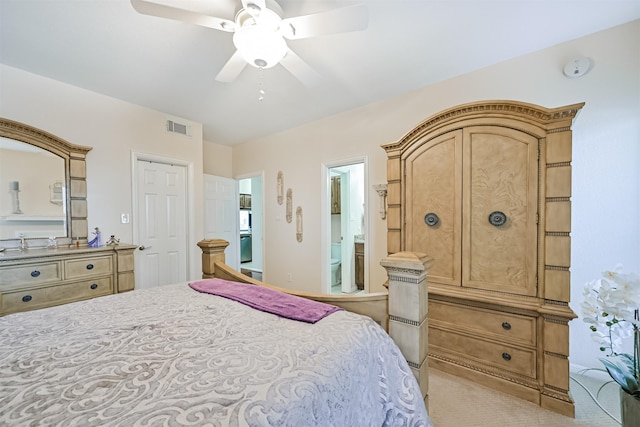 carpeted bedroom with ceiling fan, visible vents, and ensuite bathroom