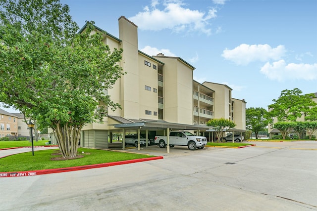 view of property with covered and uncovered parking
