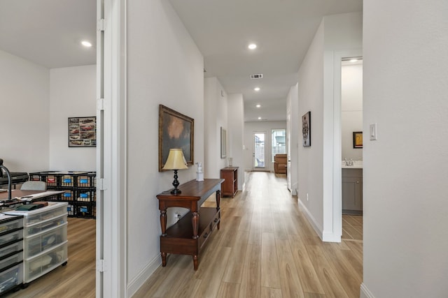 hallway with light wood-style floors, recessed lighting, baseboards, and visible vents
