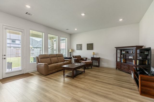 living room featuring recessed lighting, baseboards, visible vents, and light wood finished floors
