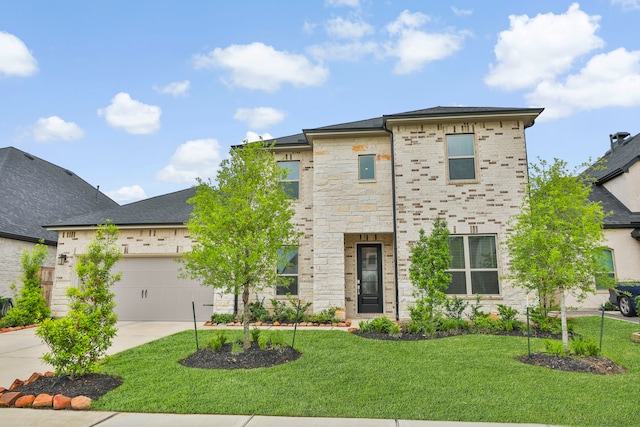 view of front of home featuring an attached garage, concrete driveway, a front lawn, and stone siding
