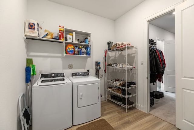 washroom featuring washer and dryer, laundry area, and light wood-type flooring
