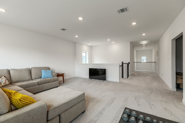 living room featuring recessed lighting, visible vents, light carpet, and attic access