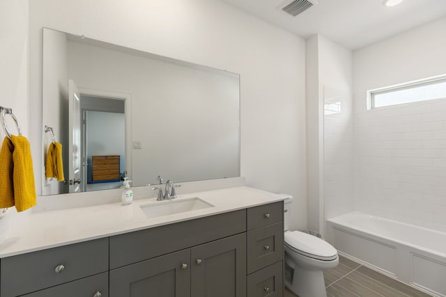 bathroom with visible vents, bathing tub / shower combination, toilet, and vanity
