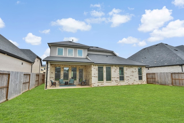 rear view of property featuring a fenced backyard, a patio, a yard, and brick siding