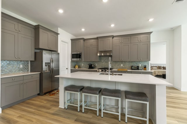 kitchen featuring gray cabinets, appliances with stainless steel finishes, and under cabinet range hood