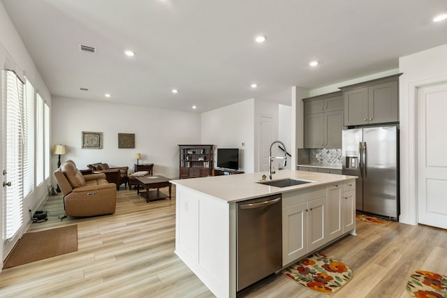 kitchen with visible vents, a sink, light countertops, open floor plan, and stainless steel appliances