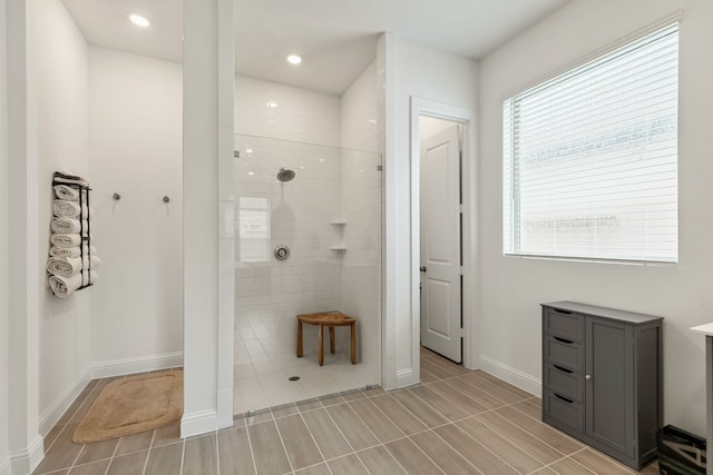 bathroom featuring baseboards, recessed lighting, and a walk in shower