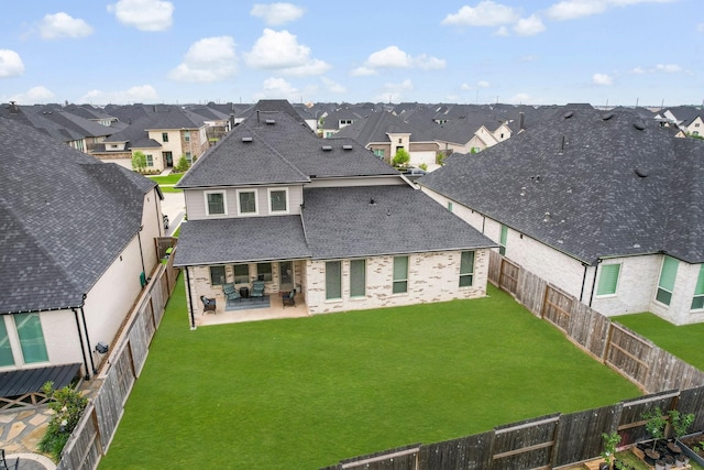back of house featuring a patio, a shingled roof, a fenced backyard, and a residential view