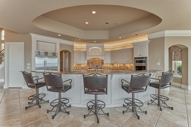 28822 Saddle Oak Dr, Montgomery, TX 77356 - kitchen with backsplash, arched walkways, stainless steel appliances, and a raised ceiling