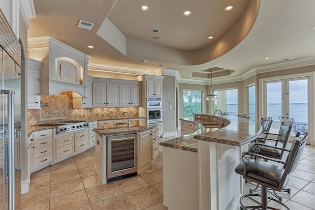 28822 Saddle Oak Dr, Montgomery, TX 77356 - kitchen with appliances with stainless steel finishes, visible vents, decorative backsplash, wine cooler, and a spacious island