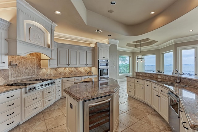 28822 Saddle Oak Dr, Montgomery, TX 77356 - kitchen featuring appliances with stainless steel finishes, a sink, wine cooler, and a tray ceiling