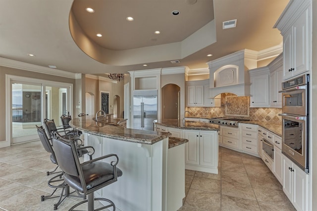 28822 Saddle Oak Dr, Montgomery, TX 77356 - kitchen with appliances with stainless steel finishes, visible vents, arched walkways, a spacious island, and ornamental molding